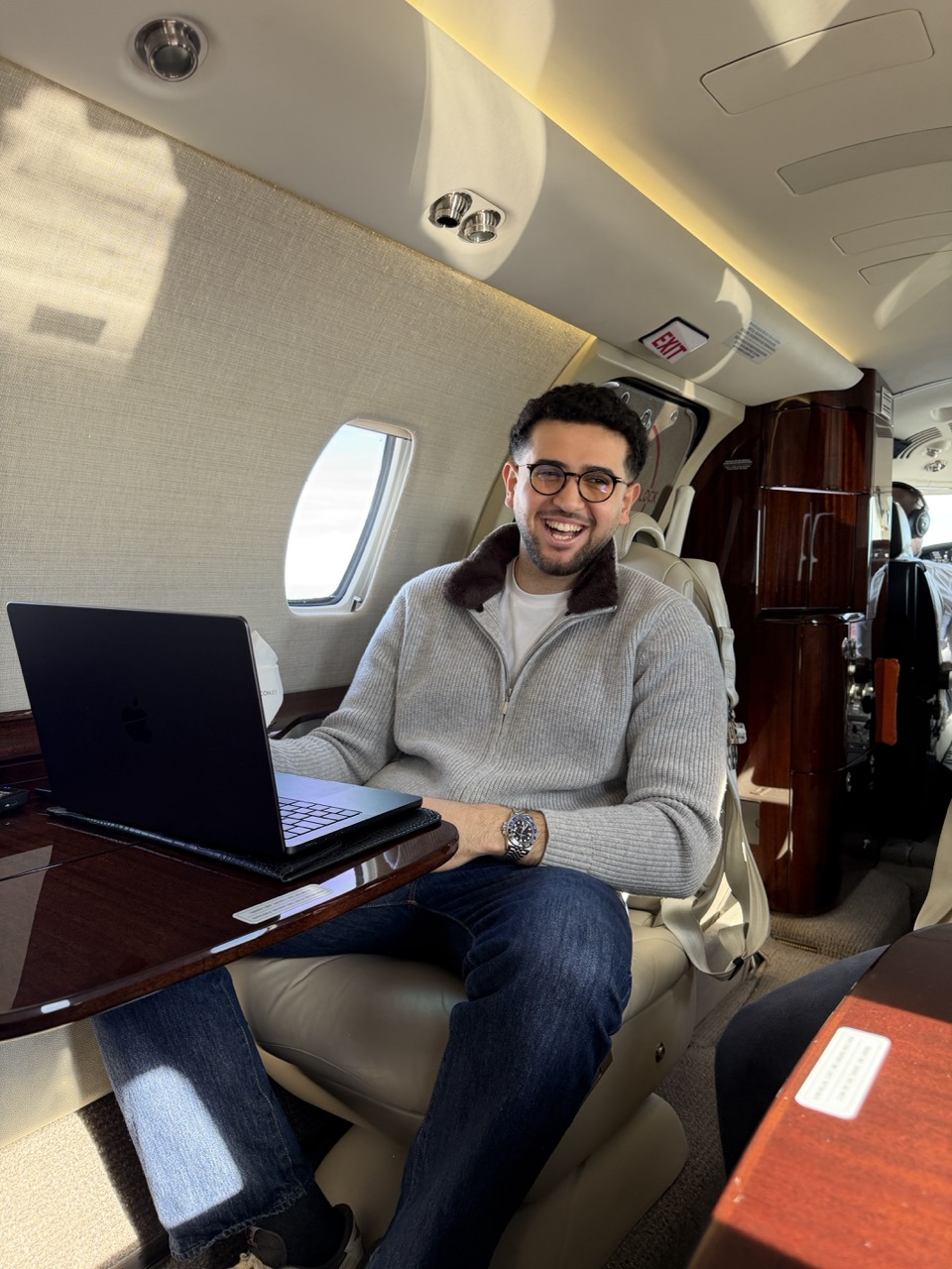 Omar Gawwad working on his laptop inside a private jet